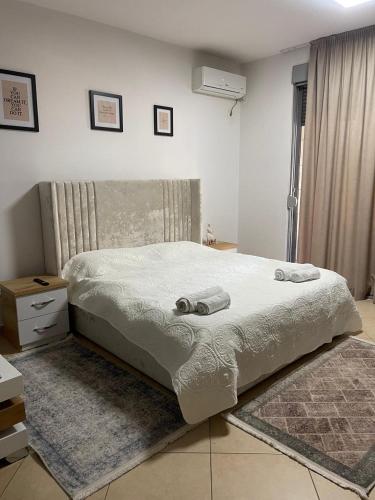 ein Schlafzimmer mit einem großen Bett mit Handtüchern darauf in der Unterkunft Sol Apartments in Tirana
