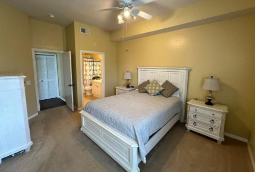 um quarto com uma cama branca e duas mesas de cabeceira em Serenade Condo On Palmer Ranch em Sarasota