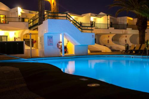una gran piscina frente a un edificio por la noche en Lanzarote Club Tahiti - July 11, 2024 until July 17, 2024 en Costa Teguise