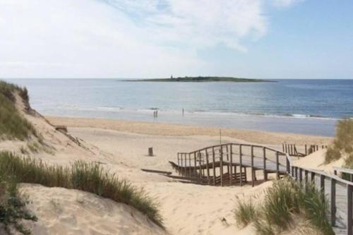 a beach with a wooden fence and the ocean at Tylösand guesthouse 300m from ocean & golf course in Halmstad