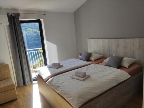 a bedroom with a large bed with two towels on it at Villa Luma Apartments in Labin