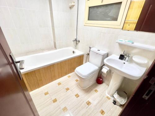 a bathroom with a sink and a toilet and a bath tub at Cozy 2 Bedroom Apartment in Al Nahda Dubai in Dubai