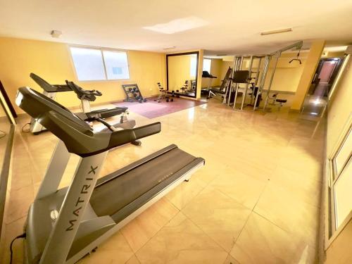 una palestra con tapis roulant e una sala fitness di Cozy 2 Bedroom Apartment in Al Nahda Dubai a Dubai