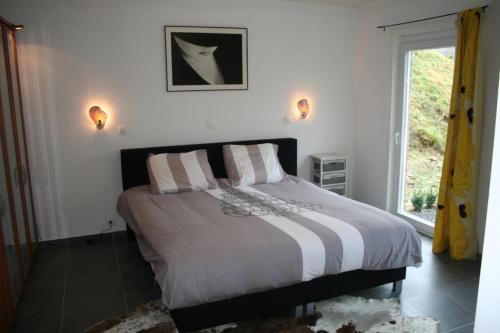 a bedroom with a large bed with a window at Holiday Home Pandora in Bouillon