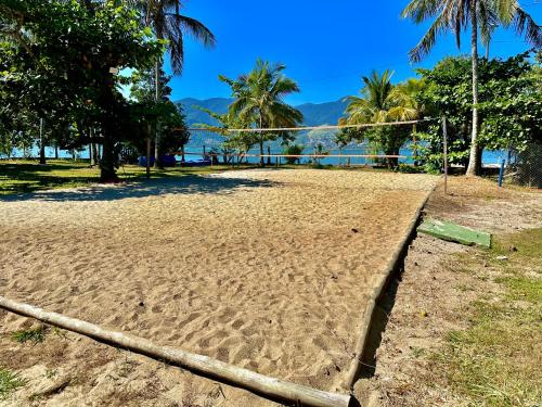 una red de voleibol en una playa de arena con el océano en Porto Grande Hotel & Convention, en São Sebastião