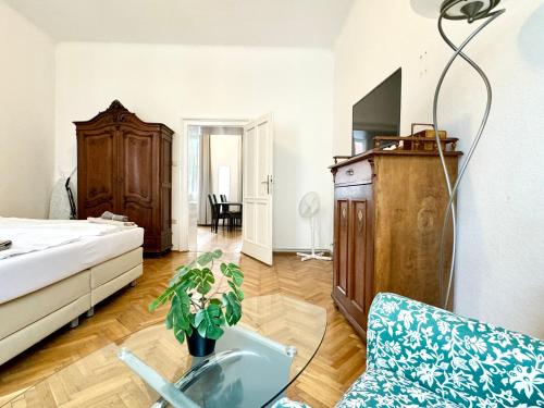 ウィーンにあるCosy Apartment located at famous Vienna Kutschkermarktのリビングルーム(ベッド1台、ガラス張りのテーブル付)