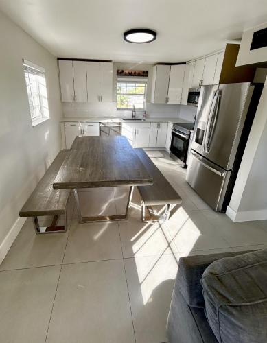 a large kitchen with a table and a refrigerator at Perfect remote work spot! Close to everything! in West Palm Beach
