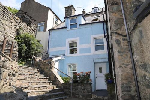 a blue house with stairs in front of it at Hen Blas, 14th century 2 bedroom Cottage in Barmouth