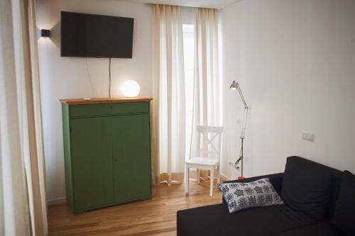 a living room with a green cabinet with a television on it at The Nook Hostel in Ponta Delgada