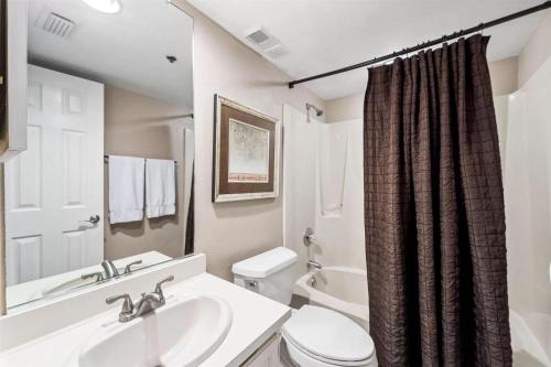 a white bathroom with a sink and a toilet at One Seagrove Place 0506 in Seagrove Beach