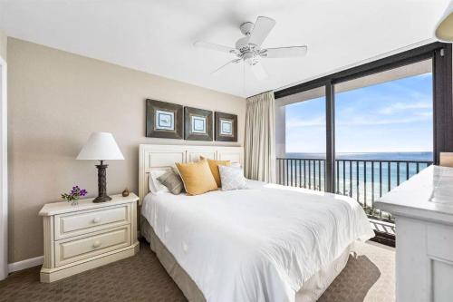 1 dormitorio con cama blanca y ventana grande en One Seagrove Place 0506, en Seagrove Beach