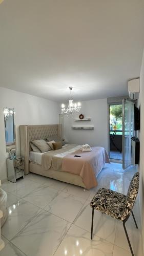 a bedroom with a bed and a chair and a chandelier at Appartement luxury in Montpellier