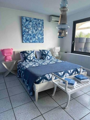 - une chambre avec un lit bleu et blanc et une fenêtre dans l'établissement Roof top piscine chauffée 7 pers wifi, à La Teste-de-Buch