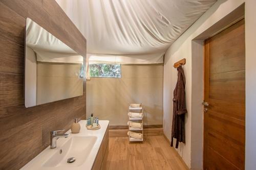 y baño con lavabo y espejo. en Mopani Safari Lodge, en Mfuwe
