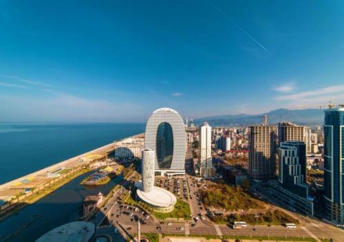 una vista aérea de una ciudad con el océano en P A N O R A M A A P R T H T E L ORBI WiTH SEA VIEW, en Batumi