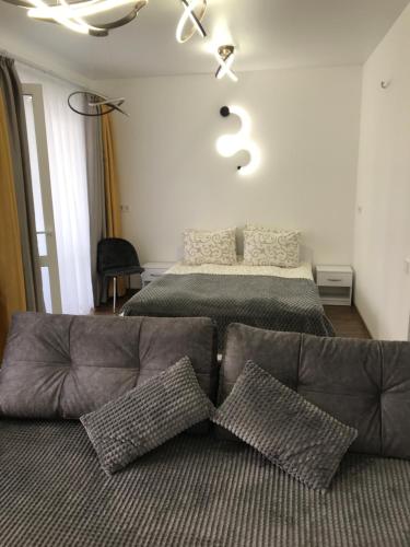a living room with a bed and a couch with pillows at Light Apartments in Chernihiv