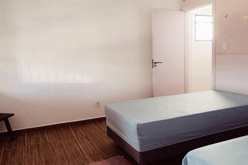 a white room with a bed and a window at Villa Brisa Azul in Atibaia