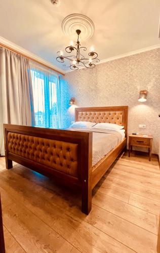 a bedroom with a large wooden bed in a room at VinoOdor - ვინოოდორ in Tʼelavi