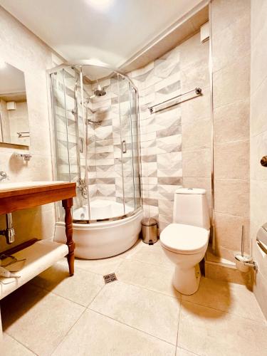 a bathroom with a shower and a toilet and a tub at VinoOdor - ვინოოდორ in Tʼelavi