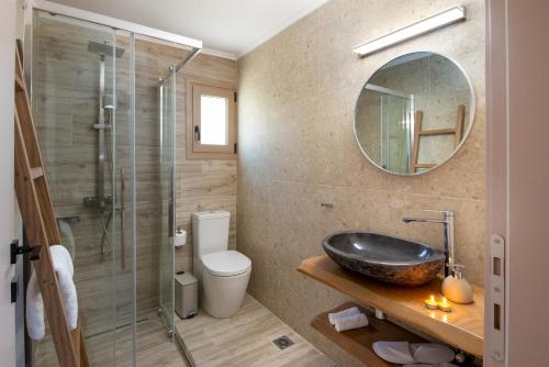 a bathroom with a sink and a toilet and a mirror at Villa Stamateli, Antipaxos in Antípaxos