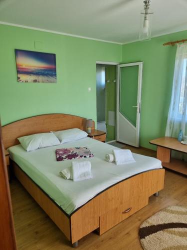 a bedroom with a large bed with green walls at Casa Antonia in Vama Veche