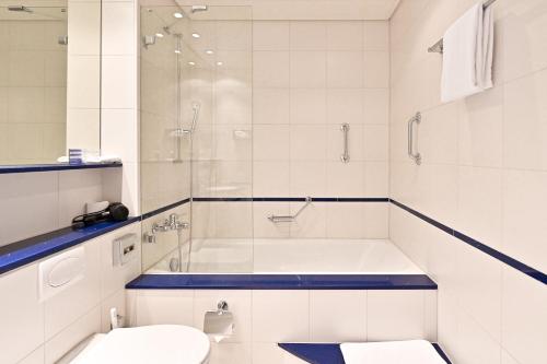 een badkamer met een bad, een toilet en een wastafel bij Hotel Zofingen in Zofingen