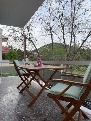 a wooden table and two chairs on a patio at Komi Beach Condo with 3 Bedrooms in Chios