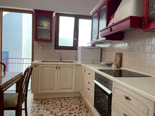 a kitchen with a sink and a stove top oven at Komi Beach Condo with 3 Bedrooms in Chios