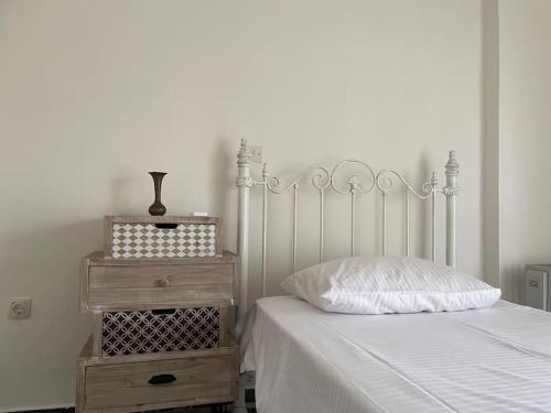 a bedroom with a bed with a white bedspread and a night stand at Komi Beach Condo with 3 Bedrooms in Chios