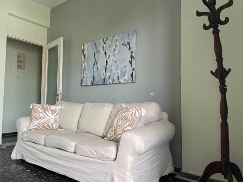 a white couch in a living room with a painting at Komi Beach Condo with 3 Bedrooms in Chios