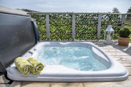 a jacuzzi tub on a patio with a fence at Tesseyman Lodge in Bubwith