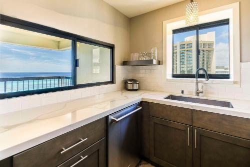 a kitchen with a sink and a large window at Aston Waikiki Beach Tower in Honolulu