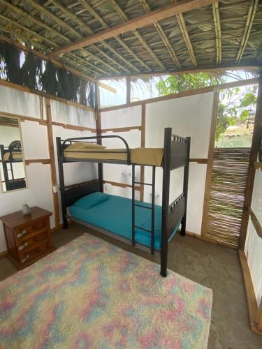 Habitación con litera y alfombra. en Aloha Surf Hostel en San José del Cabo