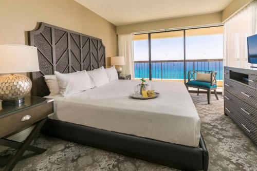 Schlafzimmer mit einem großen Bett und Meerblick in der Unterkunft Aston Waikiki Beach Tower in Honolulu