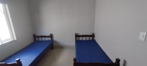 2 aparte bedden in een kamer met een raam bij Rancho Léo Artes in Três Marias