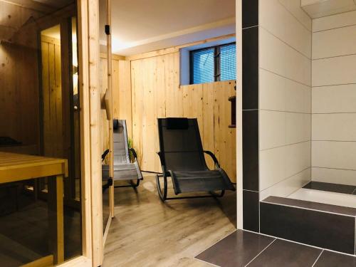 a living room with a chair and a desk at Kapitänshaus an der Warnow mit Sauna in Rostock