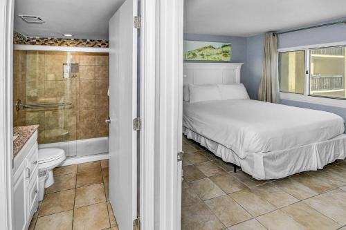 a bedroom with a bed and a shower and a bathroom at Pinnacle Port B3-307 in Carillon Beach