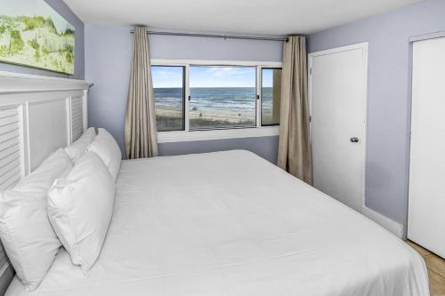 a bedroom with a white bed with a view of the ocean at Pinnacle Port B3-307 in Carillon Beach