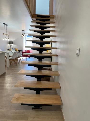 a staircase in a house with black and wooden treads at Gite de groupe lacs et forêt du jura - Orgelet in Orgelet