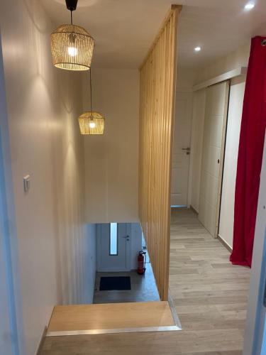 a hallway with two pendant lights and a hallway with a room with a hallway at Gite de groupe lacs et forêt du jura - Orgelet in Orgelet