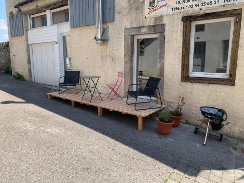 a porch with chairs and a table and a grill at Gite de groupe lacs et forêt du jura - Orgelet in Orgelet