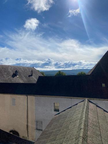 a view of the roof of a building with the sun in the sky at Gite de groupe lacs et forêt du jura - Orgelet in Orgelet