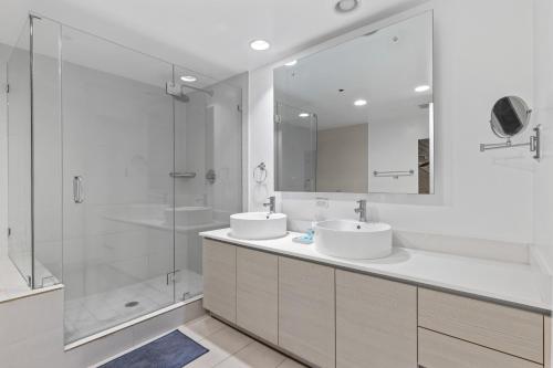 a bathroom with two sinks and a shower at Hallandale Sky Water View in Hallandale Beach