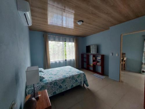 a bedroom with a bed and a window at Arenal Surá in Fortuna