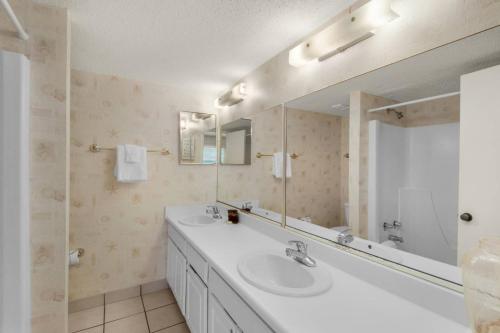 a bathroom with two sinks and a large mirror at Pinnacle Port C1-203 in Carillon Beach