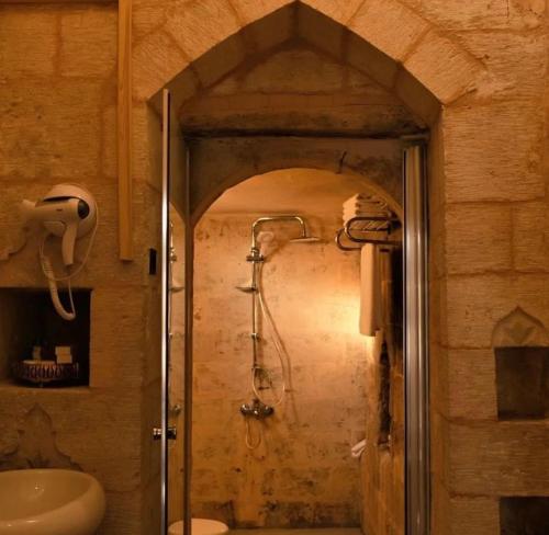 un bagno con doccia e porta in vetro di ROYAL HİSTORY HOTEL & RESORT a Mardin
