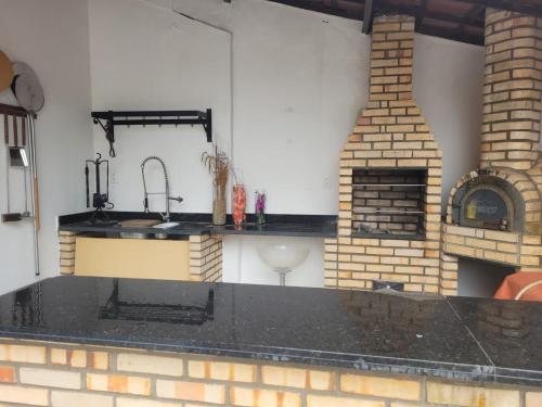 uma cozinha com um lavatório e uma lareira de tijolos em Casa para temporada - São João 2024 em Campina Grande