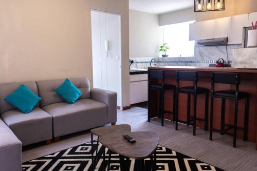 un soggiorno con divano e una cucina di Departamento confortable en San Borja a Lima