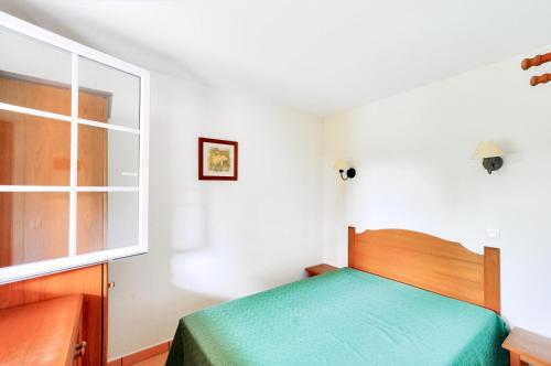 une chambre avec un lit vert et une fenêtre dans l'établissement La résidence du Lac - maeva Home - Appartement 2 pièces 5 personnes - Sélection MAE-6701, à Monflanquin
