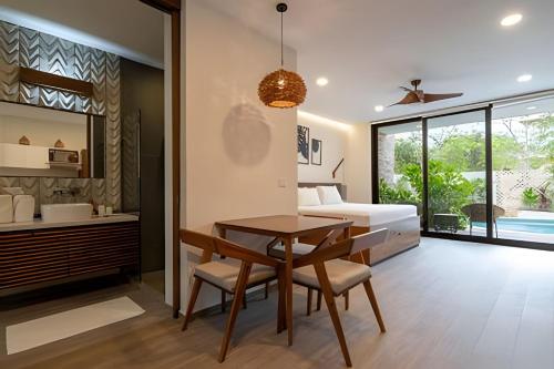 ein Schlafzimmer mit einem Bett und einem Tisch und Stühlen in der Unterkunft Moots Tulum in Tulum